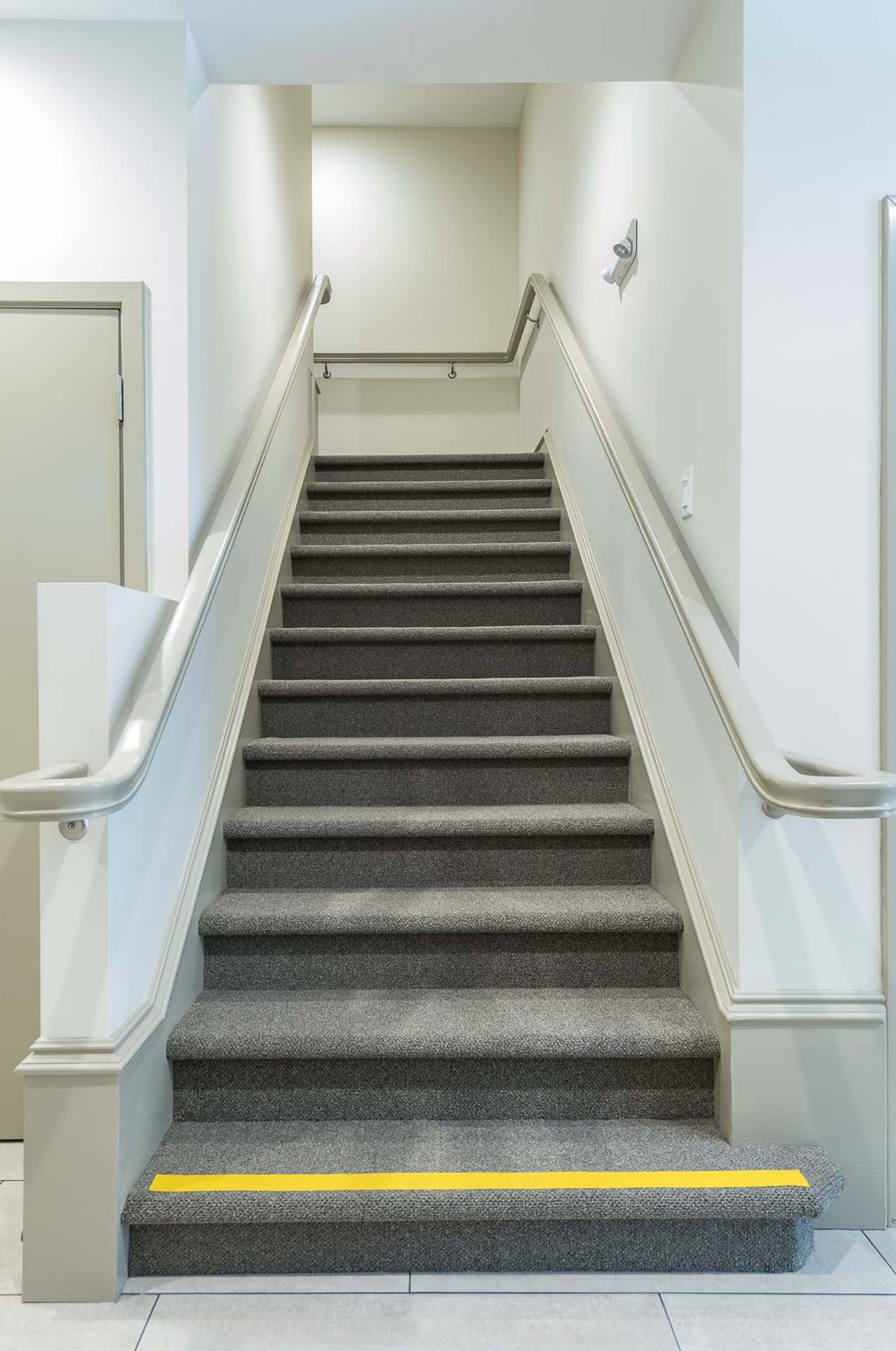 A carpet staircase with metal railing